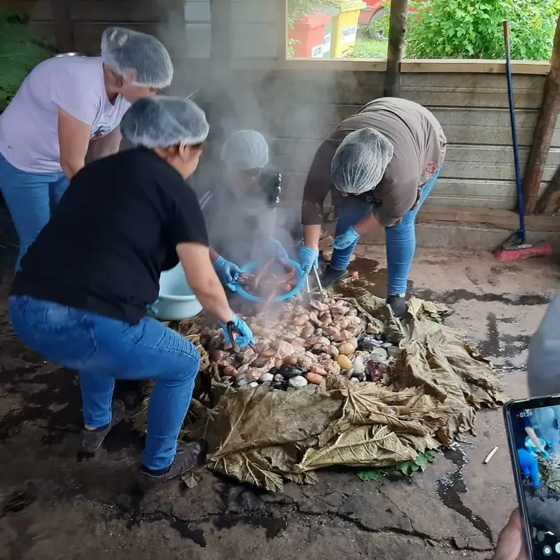 Cocineras tapando el curanto en hoyo