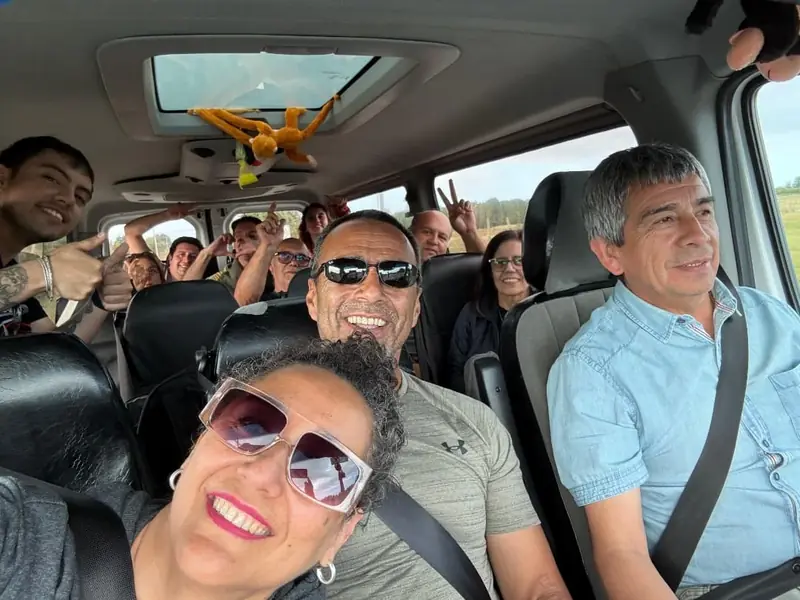 Grupo de viajeros sonriendo dentro de la van