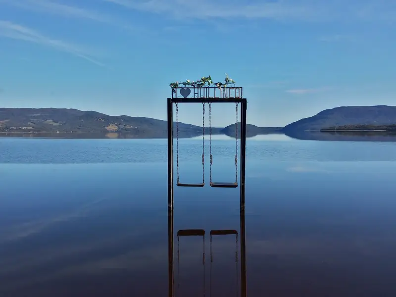 Columpio sobre el lago Huillinco, con cerros al fondo y el agua quieta