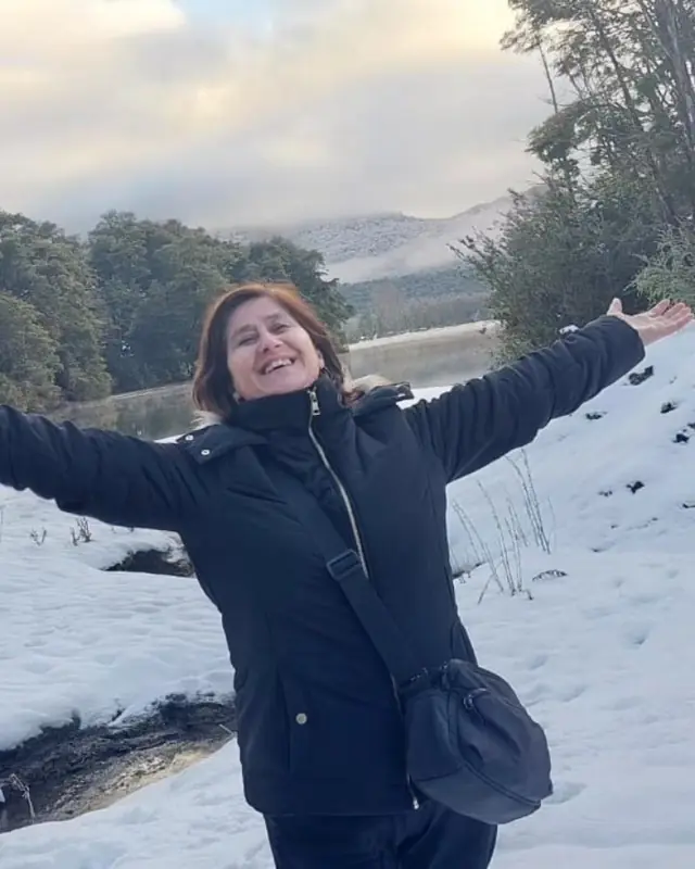 Viajera con los brazos abiertos en la nieve, en el viaje a Bariloche