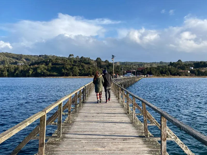 Pareja caminando por la pasarela de madera hacia la Isla Aucar