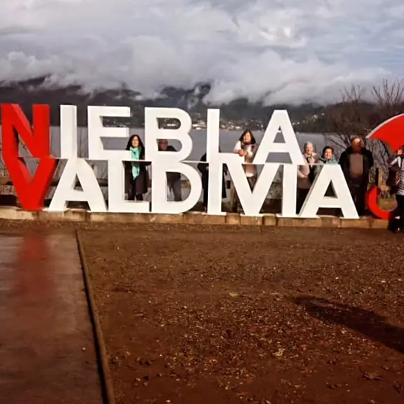 Grupo de viajeros frente al letrero de Niebla y Valdivia
